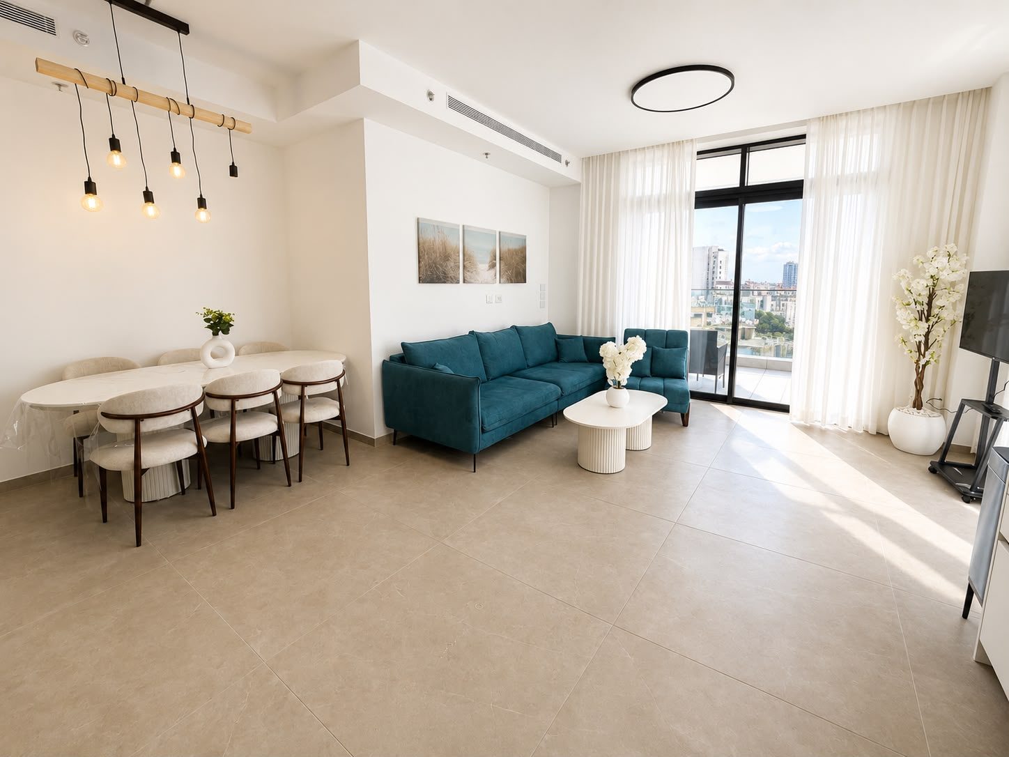 Dizengoff — Living room with dining table and teal sofa